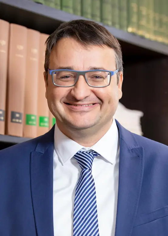 Rechtsanwalt und Fachanwalt für Arbeitsrecht Stephan Beume vor einem Bücherregal in der Rechtsanwaltskanzlei