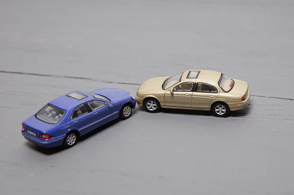 Zwei Modellautos die eine Verkehrsunfallsituation zeigen.